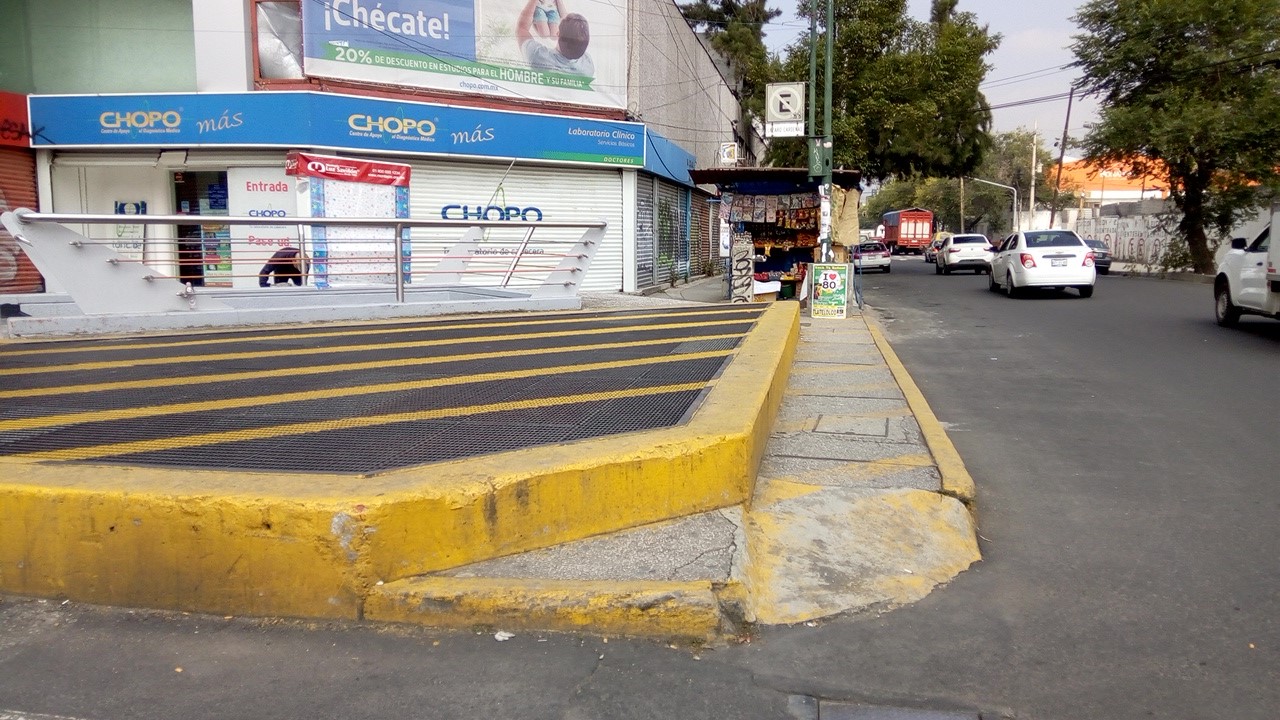 Mala calidad del pavimento en área de espera peatonal: superficie resbaladiza (respiraderos del Metro). Cruce ID: 57